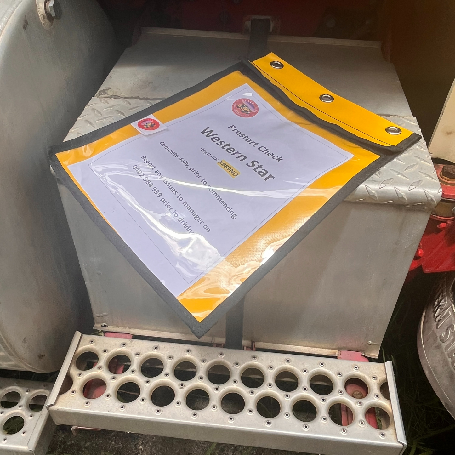 Desert Dog A4 weather resistant document wallet laying on the step of a Western Star Legend prime mover