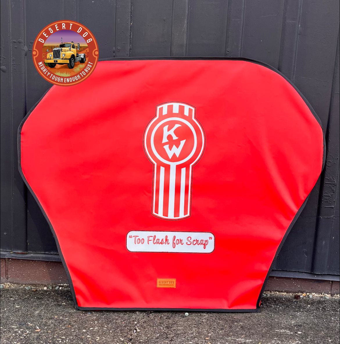 A red Jost turntable cover made by Desert Dog for the truck "Too lash for Scrap" featuring a red Kenworth logo and the truck name in text.