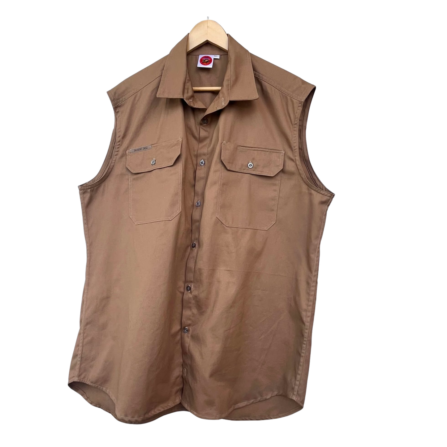 A sand coloured Desert Dog WorkTough sleeveless shirt hanging on a coat hanger