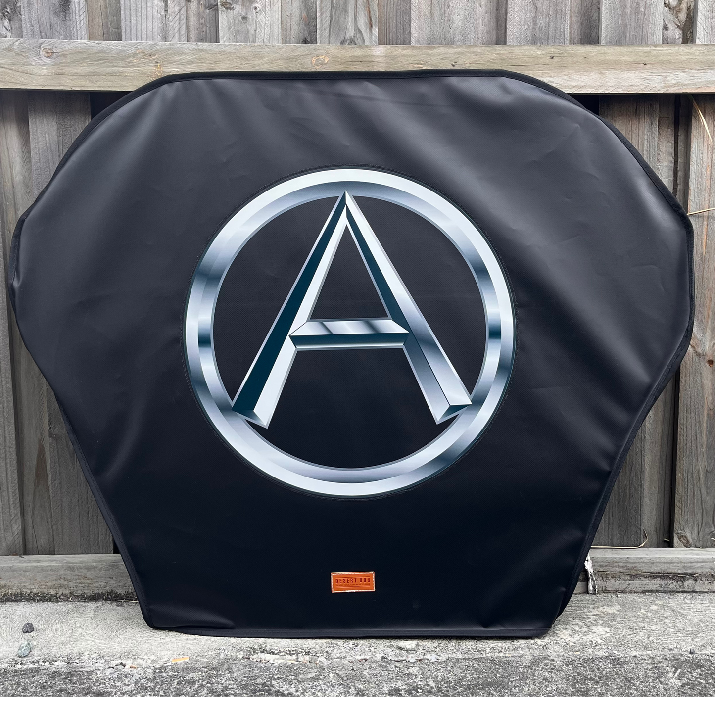 Black turn tablle cover with a Metallic A (for Atkinson) logo on a wooden fence background.