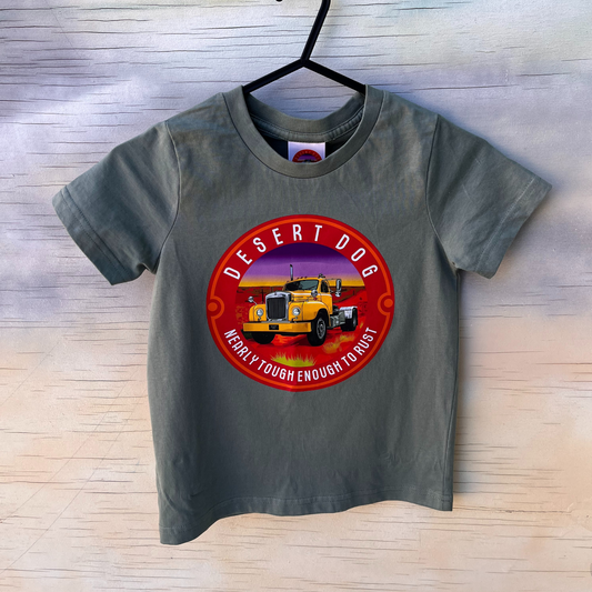 Front view of a kid's t-shirt in sage green featuring the Desert Dog logo and the words "nearly tough enough to rust:.