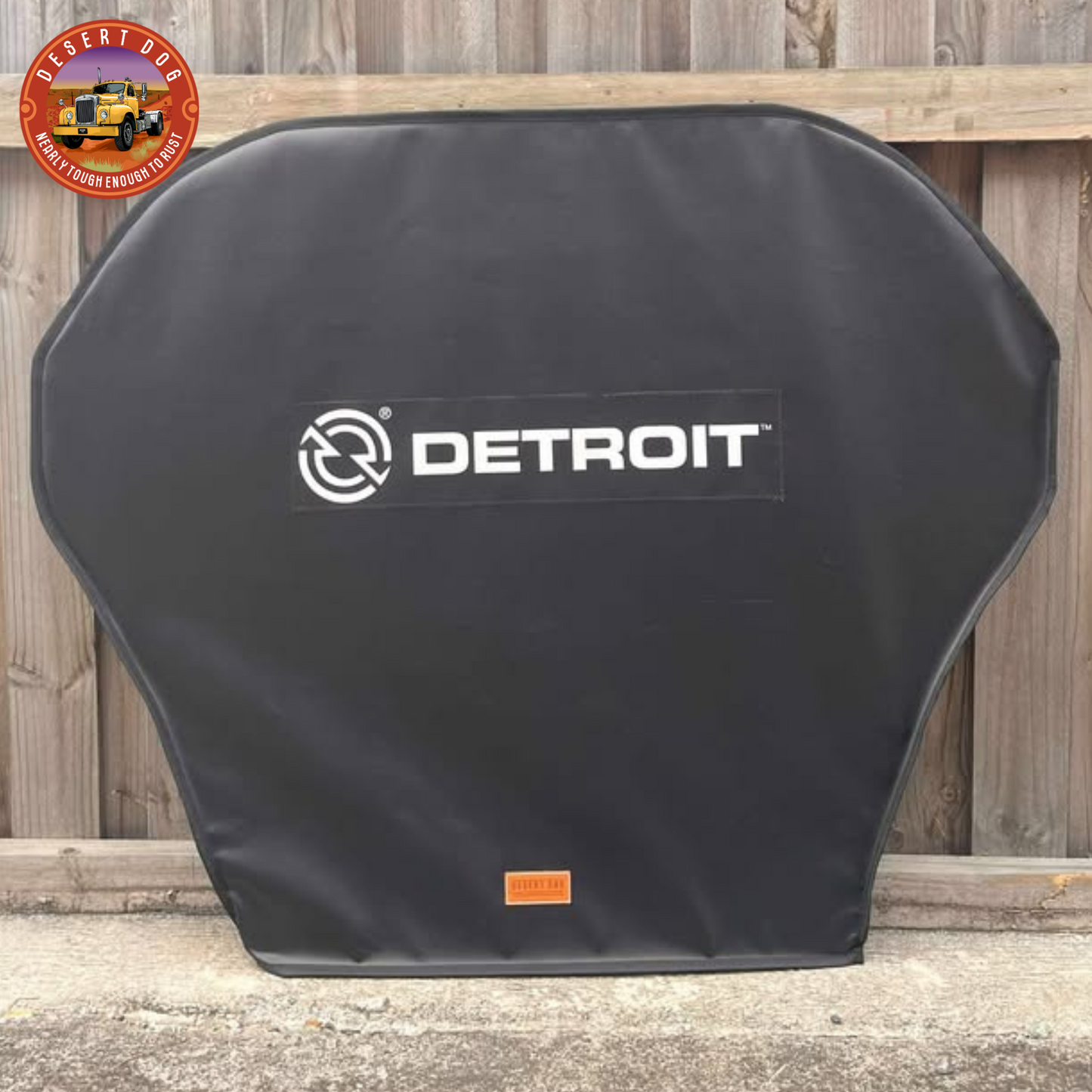 Black turn table cover with 'Detroit' logo leaning against a wooden fence