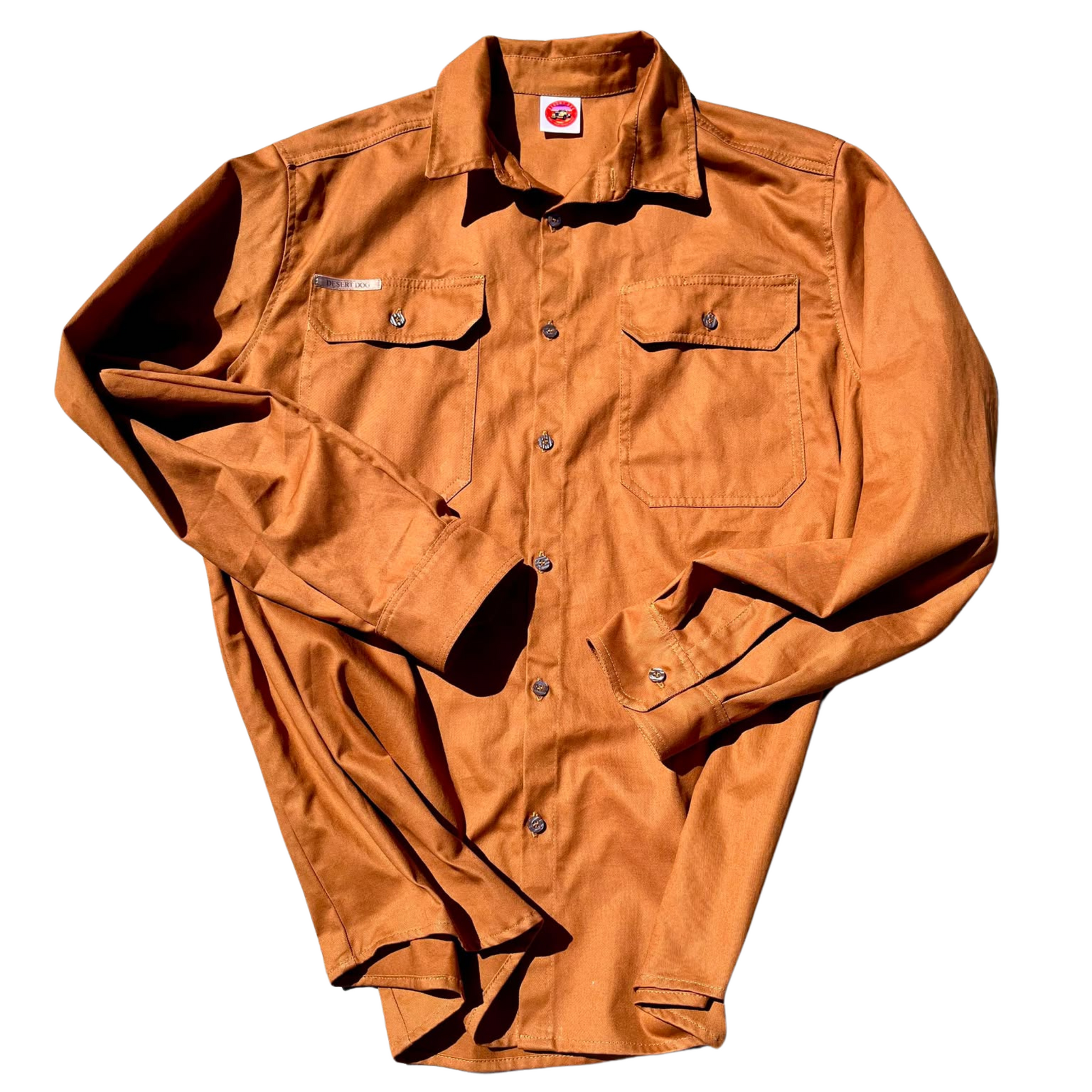 A flat lay photo of a Desert Dog WorkTough shirt, long sleeved and rust coloured.